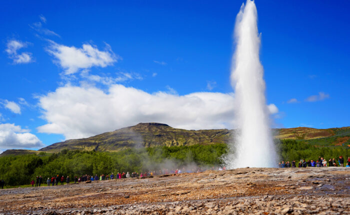 In Geysir geothermal area, Strokkur erupts regularly. Mt. Bjarnafell in the background.