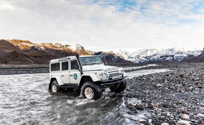 A modified jeep crosses an ice-covered river in Þórsmörk Iceland.