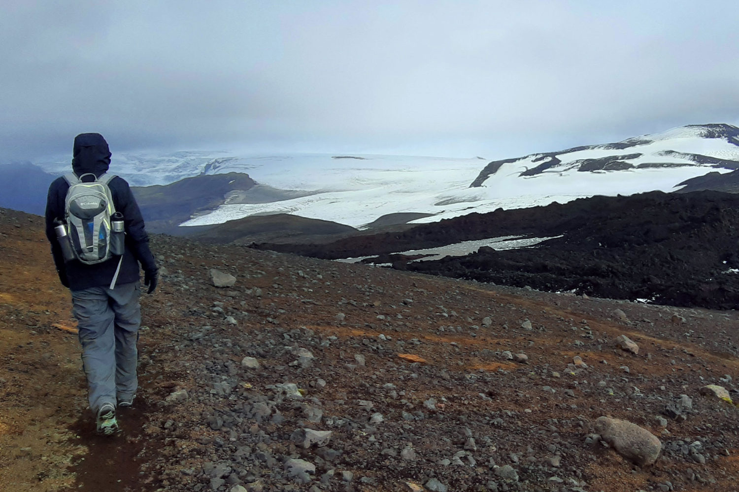 A hiker in a fog looks at Mýrdalsjökull.