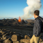 Man looking at an active volcano