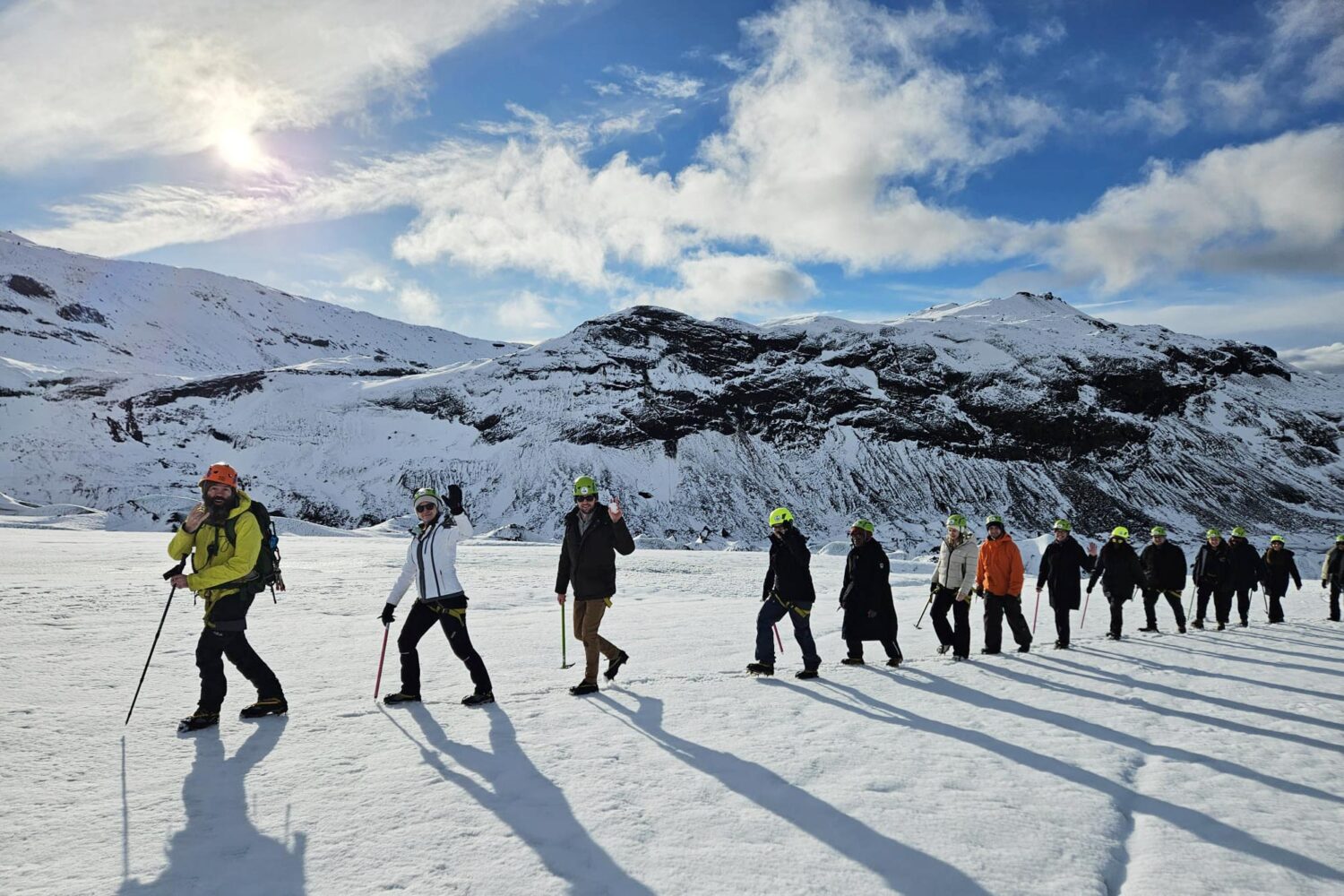 People walking in a single file line on the glacier.