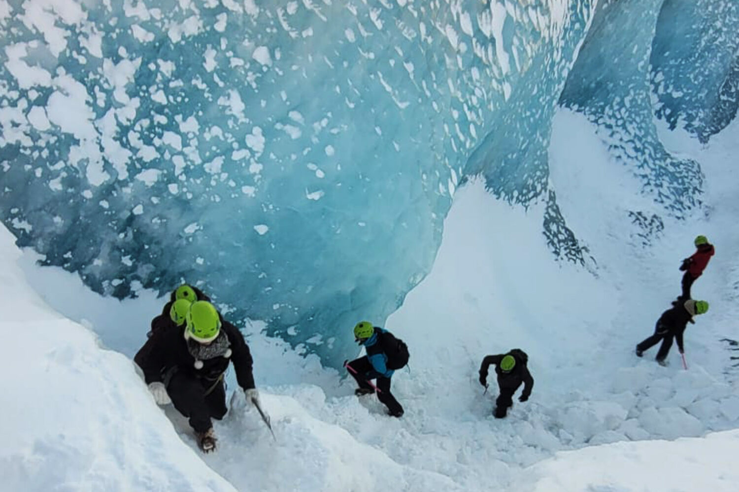 People climing out of a large crevasse