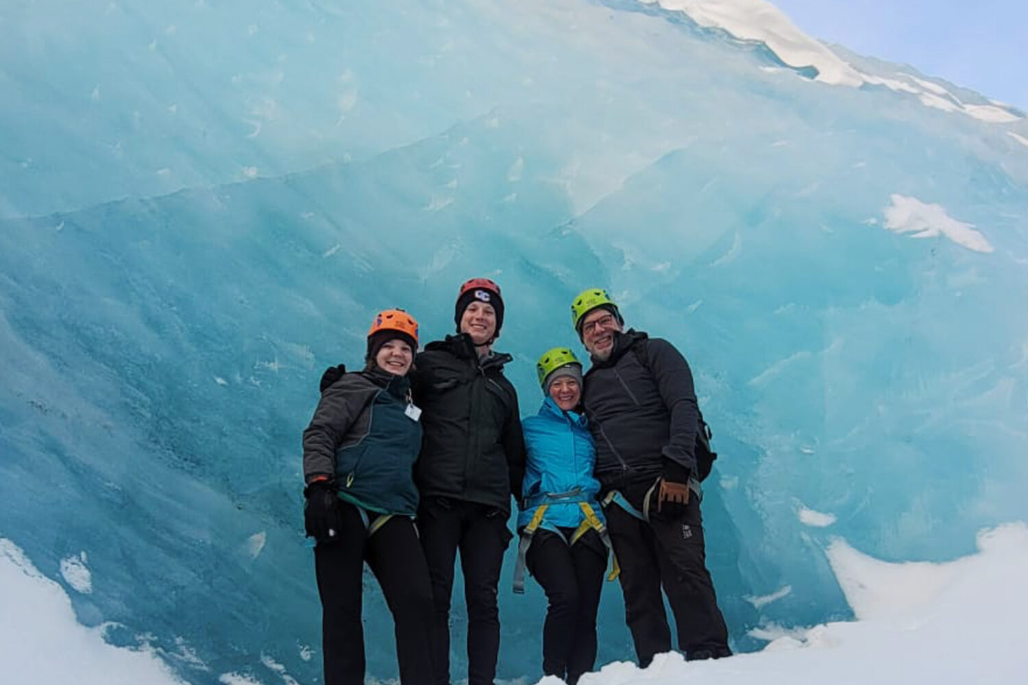 Family photo in front of a wall of blue ice