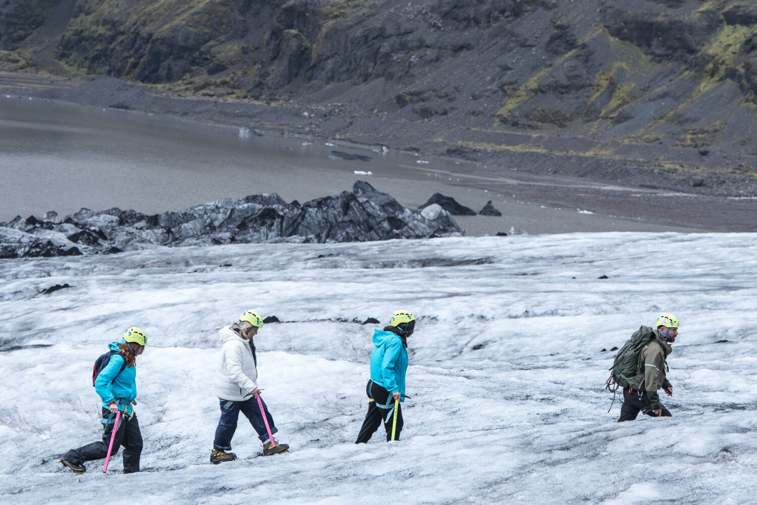 People hiking in a single file line on the glacier.