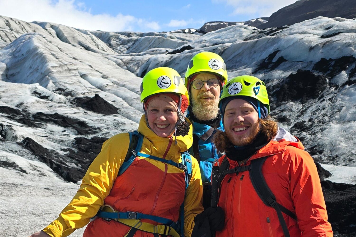 Family of three standing on the glacier.