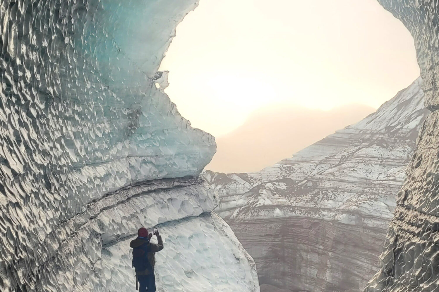 Man taking a photo inside an ice cave.