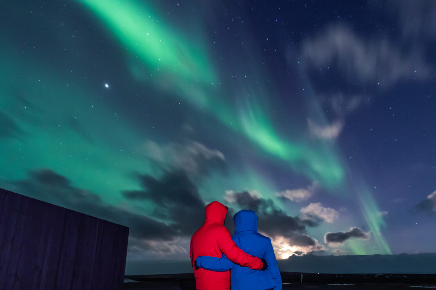 A couple in love looking at the Northern Lights in Iceland together.