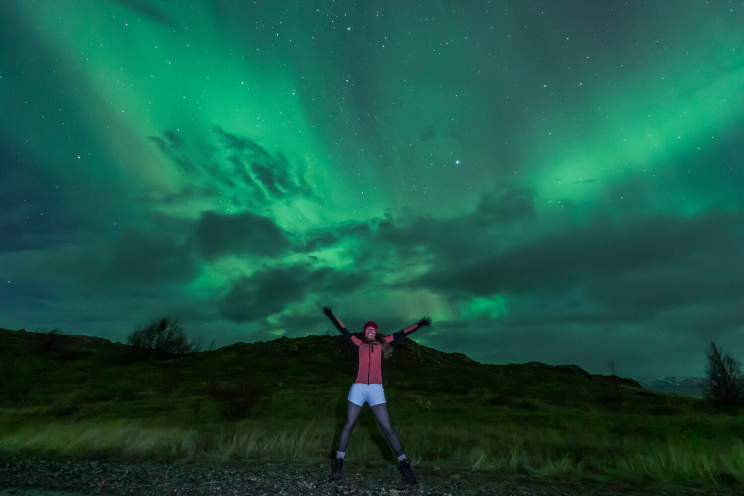 Woman under the aurora's glow.