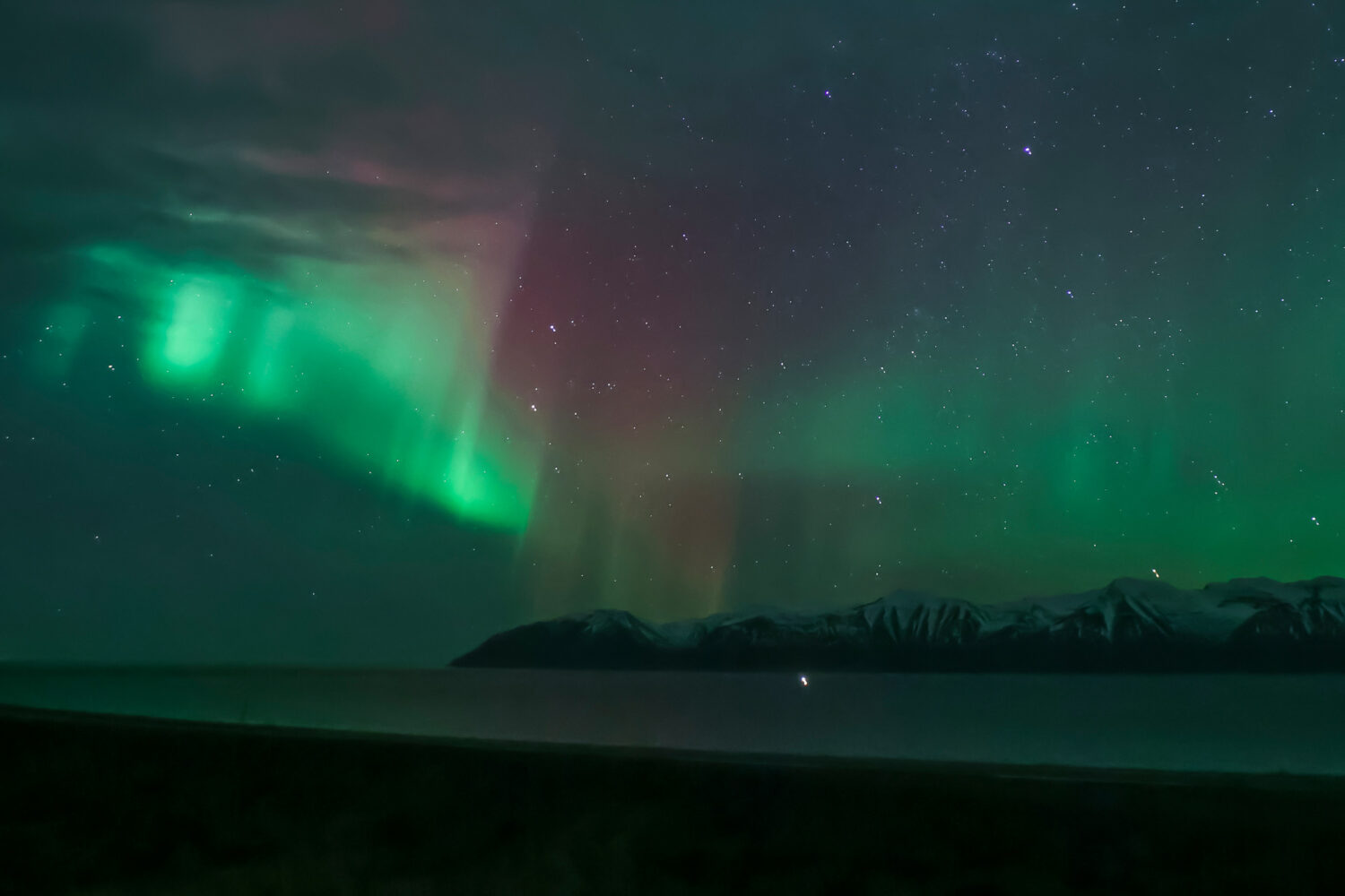 The auroras flicker like ethereal flames, illuminating the vastness of the winter sky.