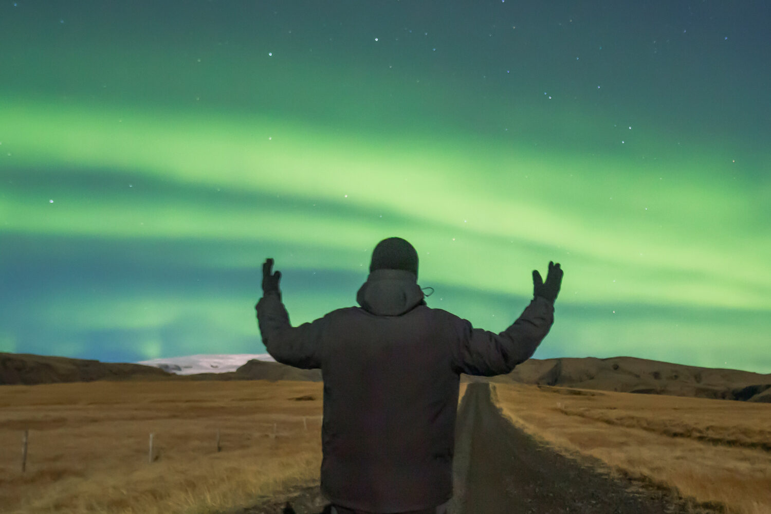 A man standing under the auroras in Iceland