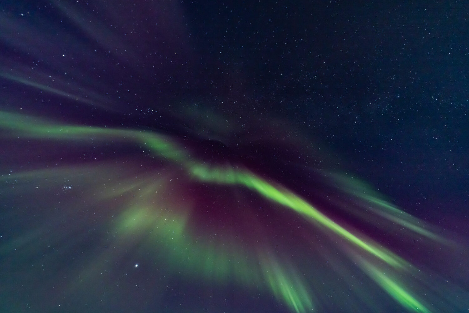 The Northern Lights dance across the night sky.